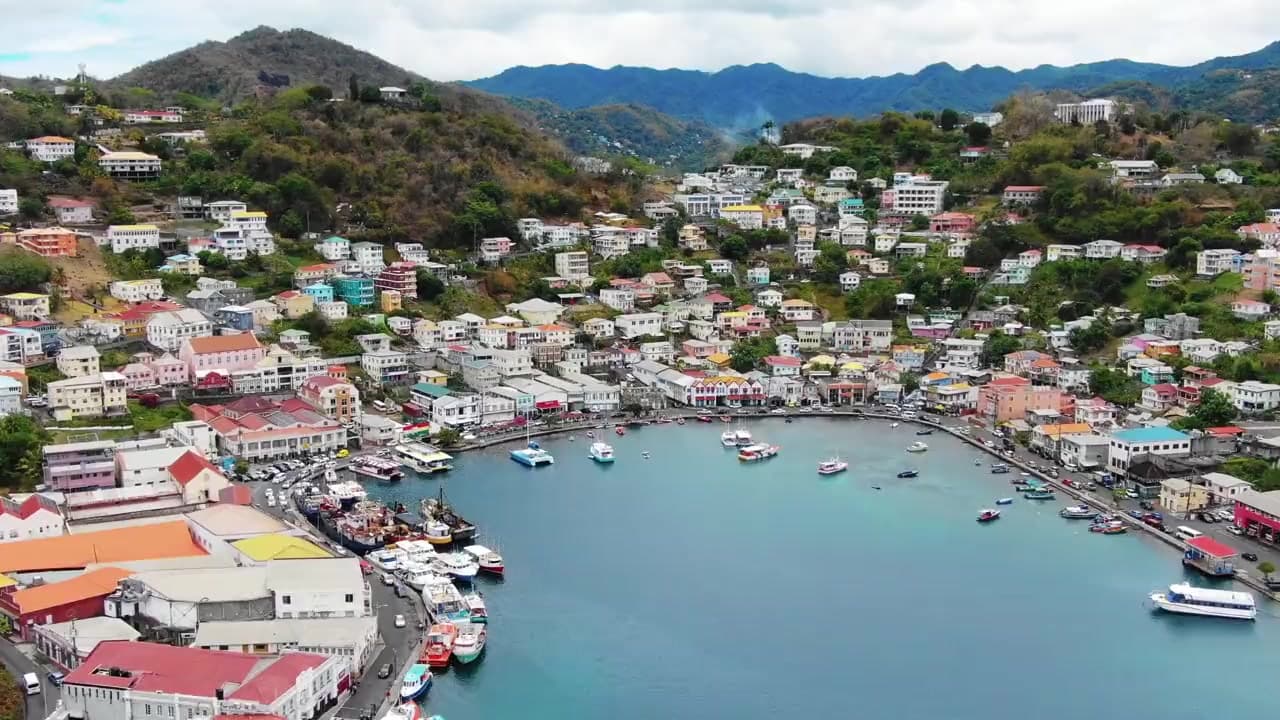 Aerial view of the Carenage, the horseshoe harbour at St. George's, Grenada, with pastel buildings rising up the hillside